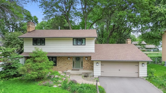 6521 Gleason Rd, Edina, MN 55439 - view of front of home with a chimney, driveway, an attached garage, a shingled roof, and brick siding