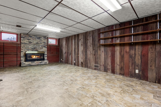 6521 Gleason Rd, Edina, MN 55439 - basement with wooden walls, a brick fireplace, healthy amount of natural light, and a drop ceiling