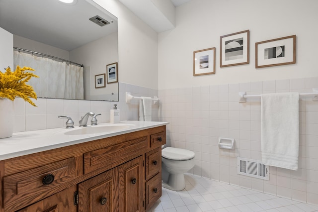 6521 Gleason Rd, Edina, MN 55439 - full bathroom with tile walls, vanity, tile patterned floors, and wainscoting