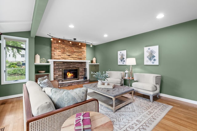 6521 Gleason Rd, Edina, MN 55439 - living room with wood finished floors, a stone fireplace, track lighting, and recessed lighting