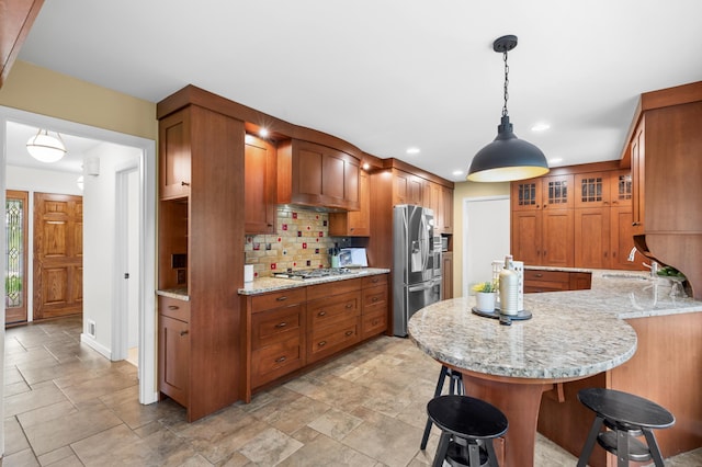 6521 Gleason Rd, Edina, MN 55439 - kitchen featuring stainless steel appliances, brown cabinets, a kitchen breakfast bar, tasteful backsplash, and a peninsula