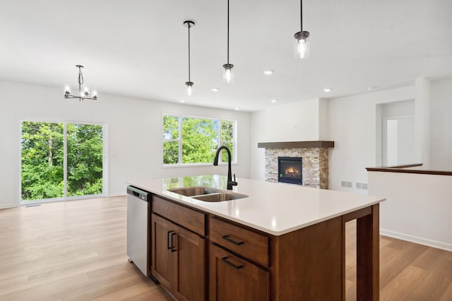 10633 29th St NE, Saint Michael, MN 55376 - kitchen featuring dishwasher, a sink, light wood-style flooring, a fireplace, and light countertops