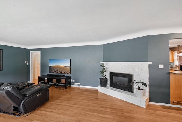 1346 Como Ave, Saint Paul, MN 55108 - living area with light wood-style floors, a fireplace, and arched walkways