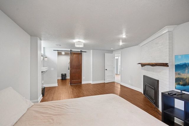 1346 Como Ave, Saint Paul, MN 55108 - bedroom with a barn door, wood finished floors, and a brick fireplace