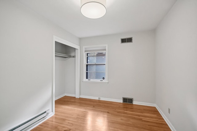 1346 Como Ave, Saint Paul, MN 55108 - unfurnished bedroom with a baseboard radiator, wood finished floors, and a closet