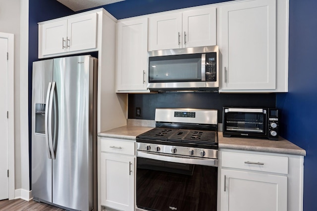 11505 Pineridge Way N, Dayton, MN 55327 - kitchen with appliances with stainless steel finishes, white cabinets, and wood finished floors