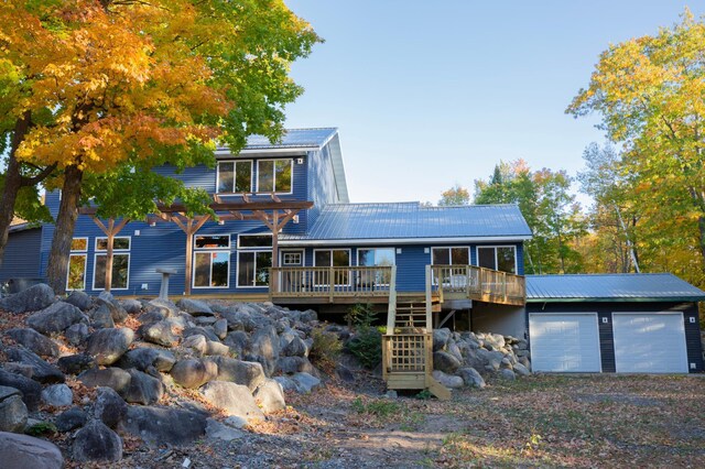 6860 Re Echo Ridge Dr NE, Remer, MN 56672 - view of front of house with a wooden deck, metal roof, an attached garage, and stairs