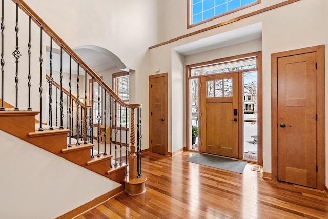 9256 Gateway Ln, Eden Prairie, MN 55347 - entryway featuring a high ceiling, arched walkways, wood-type flooring, baseboards, and stairs