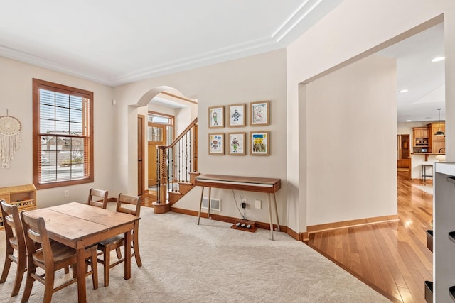 9256 Gateway Ln, Eden Prairie, MN 55347 - dining space featuring stairway, arched walkways, baseboards, light wood-type flooring, and recessed lighting