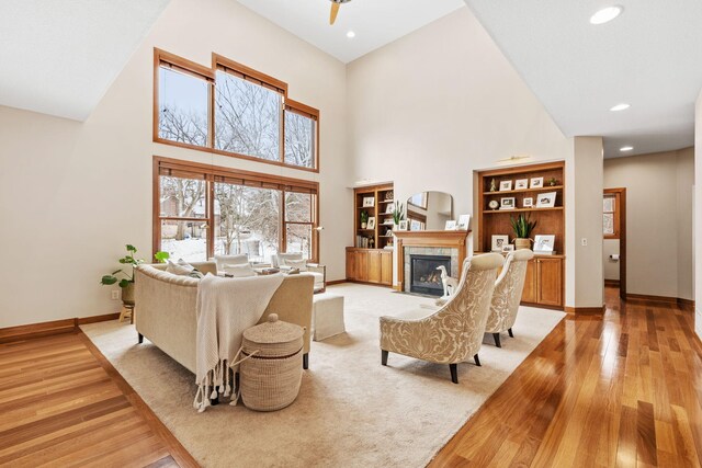 9256 Gateway Ln, Eden Prairie, MN 55347 - living area with a towering ceiling, a tiled fireplace, light wood finished floors, baseboards, and plenty of natural light