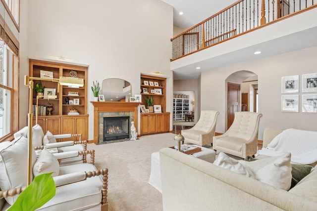 9256 Gateway Ln, Eden Prairie, MN 55347 - living area featuring a high ceiling, arched walkways, carpet flooring, a tile fireplace, and built in features
