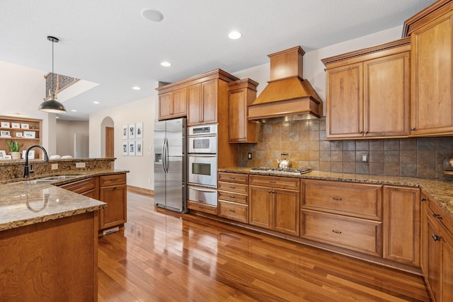 9256 Gateway Ln, Eden Prairie, MN 55347 - kitchen with appliances with stainless steel finishes, custom range hood, a sink, a warming drawer, and arched walkways