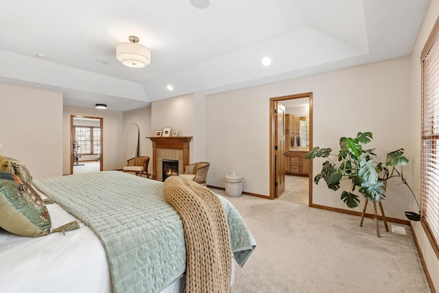 9256 Gateway Ln, Eden Prairie, MN 55347 - bedroom featuring light carpet, baseboards, a tray ceiling, a tiled fireplace, and recessed lighting