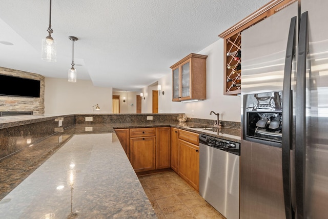 9256 Gateway Ln, Eden Prairie, MN 55347 - kitchen featuring appliances with stainless steel finishes, a sink, brown cabinets, pendant lighting, and a textured ceiling