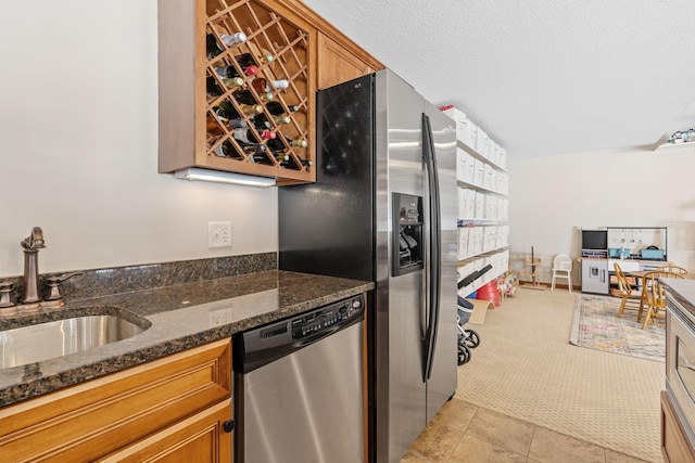 9256 Gateway Ln, Eden Prairie, MN 55347 - kitchen with stainless steel appliances, a sink, brown cabinets, and dark stone counters