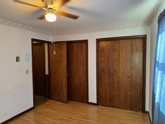 206 3rd St E, Brandon, MN 56315 - unfurnished bedroom with multiple closets, light wood-type flooring, baseboards, and a ceiling fan