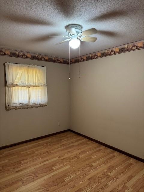206 3rd St E, Brandon, MN 56315 - empty room featuring a textured ceiling, light wood-style floors, a ceiling fan, and baseboards