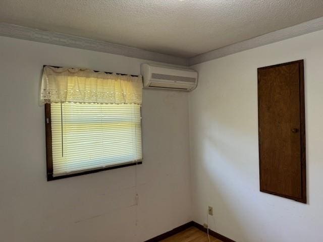 206 3rd St E, Brandon, MN 56315 - spare room with a wall mounted AC, wood finished floors, a textured ceiling, and baseboards
