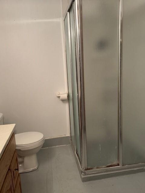 206 3rd St E, Brandon, MN 56315 - bathroom featuring vanity, a stall shower, toilet, finished concrete flooring, and baseboards