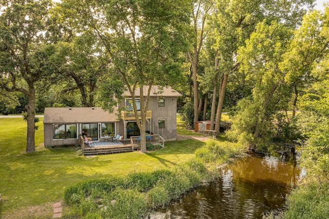 21400 654th Ave, Darwin, MN 55324 - rear view of property featuring a deck with water view, a lawn, roof with shingles, and view of scattered trees