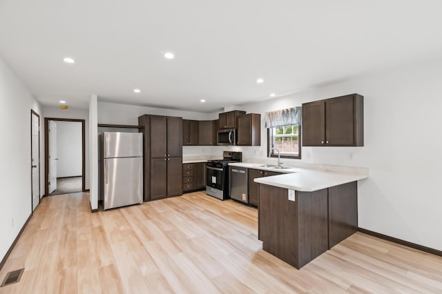 215 Mckay Ave # 59, Alexandria, MN 56308 - kitchen with stainless steel appliances, a sink, dark brown cabinets, a peninsula, and light countertops