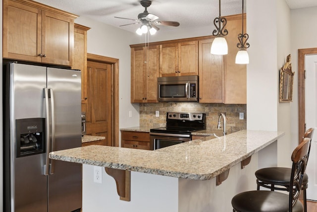 2670 Kelley Pkwy Unit 115, Orono, MN 55356 - kitchen with appliances with stainless steel finishes, a peninsula, decorative backsplash, light stone counters, and a ceiling fan