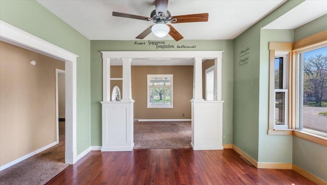 1125 9th Ave SE, Saint Cloud, MN 56304 - spare room with hardwood / wood-style flooring, baseboards, ornate columns, and ceiling fan