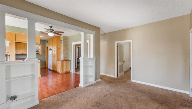 1125 9th Ave SE, Saint Cloud, MN 56304 - unfurnished living room with decorative columns, carpet flooring, baseboards, and ceiling fan