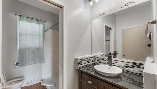 1125 9th Ave SE, Saint Cloud, MN 56304 - bathroom featuring vanity, decorative backsplash, toilet, and a shower