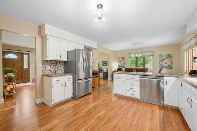 1501 Fraser Dr, Grand Rapids, MN 55744 - kitchen featuring appliances with stainless steel finishes, light wood-type flooring, healthy amount of natural light, and white cabinetry