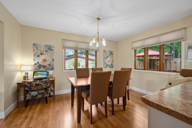 1501 Fraser Dr, Grand Rapids, MN 55744 - dining space featuring light wood-type flooring, baseboards, and a chandelier
