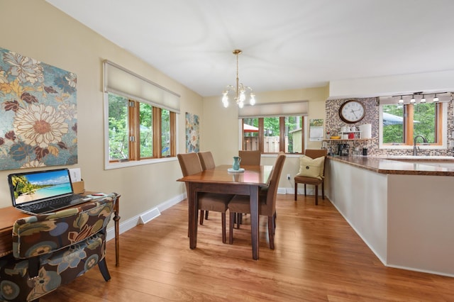 1501 Fraser Dr, Grand Rapids, MN 55744 - dining room featuring a chandelier, healthy amount of natural light, light wood-type flooring, and baseboards