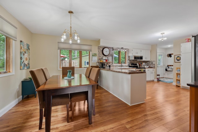 1501 Fraser Dr, Grand Rapids, MN 55744 - dining area featuring a chandelier, plenty of natural light, light wood-style floors, and baseboards