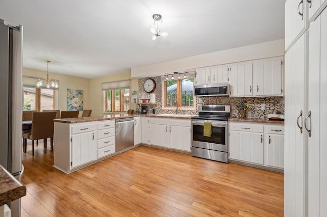 1501 Fraser Dr, Grand Rapids, MN 55744 - kitchen with appliances with stainless steel finishes, a chandelier, light wood finished floors, and white cabinetry