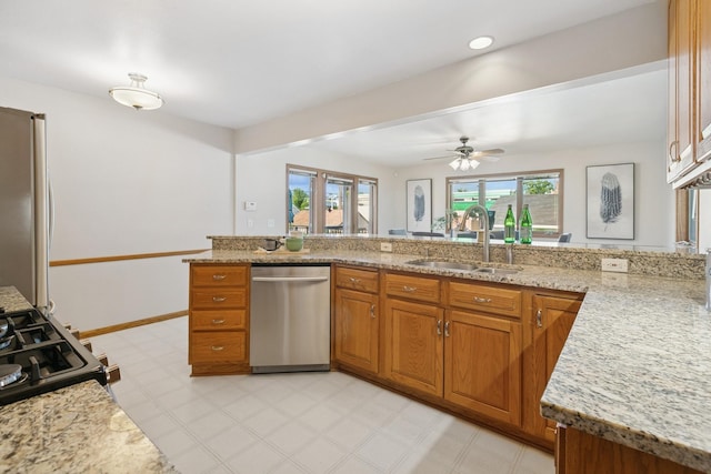 5409 Aldrich Ave S, Minneapolis, MN 55419 - kitchen featuring stainless steel appliances, brown cabinetry, a ceiling fan, and light stone countertops