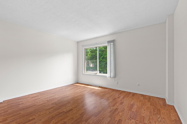 4100 Meadowlark Ln Unit 24100, Eagan, MN 55122 - unfurnished room featuring wood finished floors, baseboards, and a textured ceiling
