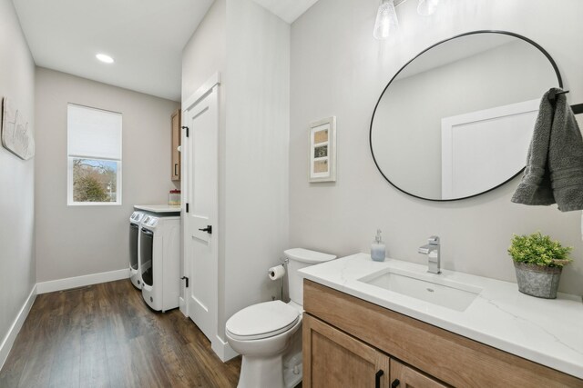 2401 Goldfinch Ln, Buffalo, MN 55313 - bathroom featuring washer and dryer, vanity, wood finished floors, toilet, and baseboards