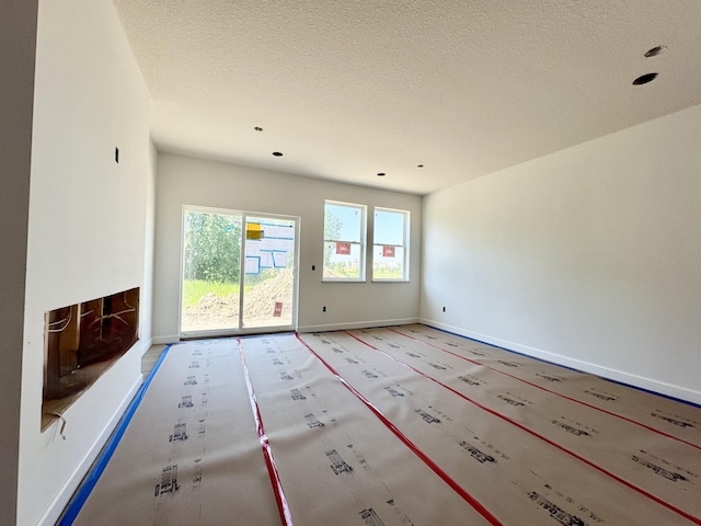 10049 73rd Ln NE, Otsego, MN 55330 - unfurnished living room featuring baseboards and a textured ceiling