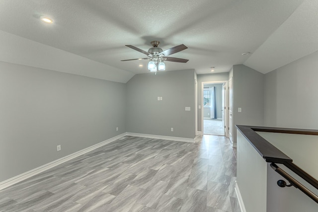 8799 Irving Blvd N, Lake Elmo, MN 55042 - additional living space with vaulted ceiling, ceiling fan, baseboards, a textured ceiling, and recessed lighting