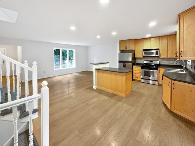 7040 Winfield Rd, Rockford, MN 55373 - kitchen with appliances with stainless steel finishes, a sink, dark countertops, a center island, and backsplash