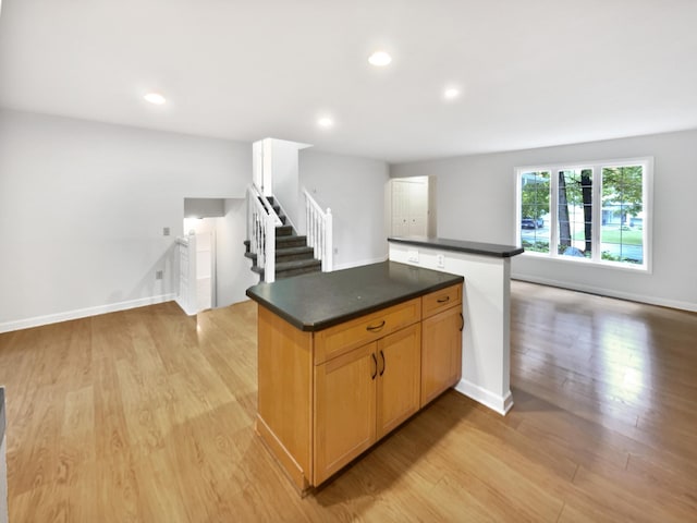 7040 Winfield Rd, Rockford, MN 55373 - kitchen with dark countertops, light wood-style floors, a center island, recessed lighting, and open floor plan