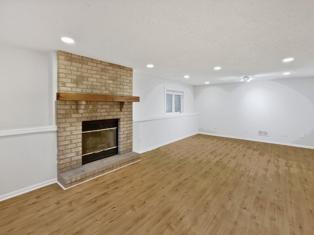 7040 Winfield Rd, Rockford, MN 55373 - unfurnished living room with a brick fireplace, light wood-style floors, recessed lighting, and baseboards