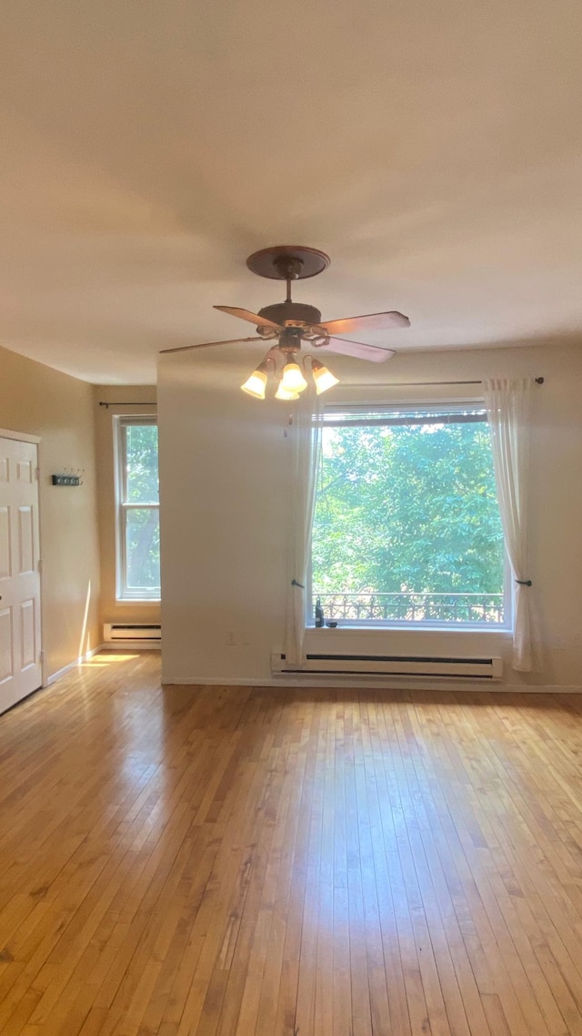 703 Laurel Ave Unit 4W, Saint Paul, MN 55104 - spare room featuring a baseboard heating unit, light wood-style floors, and ceiling fan