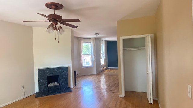 703 Laurel Ave Unit 4W, Saint Paul, MN 55104 - unfurnished living room featuring wood finished floors, ceiling fan, baseboards, and a fireplace