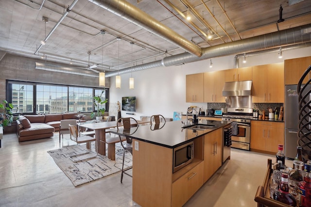 525 3rd St Unit 502, Minneapolis, MN 55401 - kitchen featuring appliances with stainless steel finishes, under cabinet range hood, dark countertops, concrete floors, and backsplash