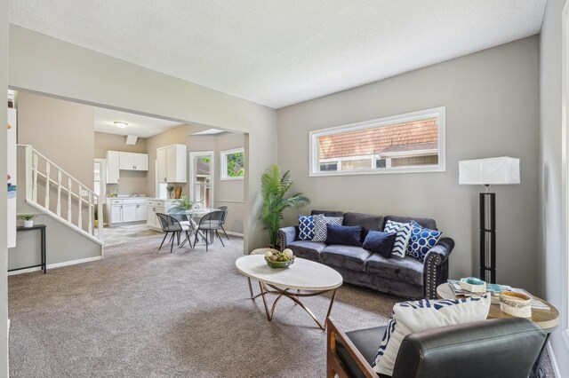 2619 23rd Ave N, Minneapolis, MN 55411 - living room with light colored carpet, stairway, and a textured ceiling