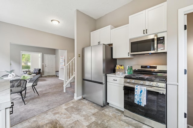 2619 23rd Ave N, Minneapolis, MN 55411 - kitchen featuring appliances with stainless steel finishes, white cabinets, and light colored carpet