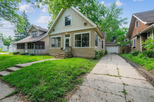2619 23rd Ave N, Minneapolis, MN 55411 - bungalow-style house with an outdoor structure, a garage, a front yard, stucco siding, and driveway