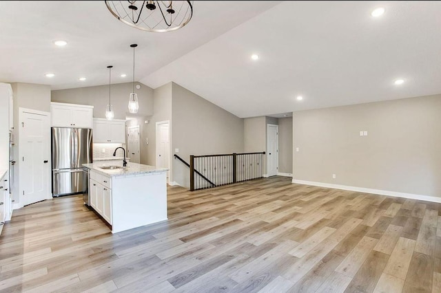 12620 Overlook Rd, Dayton, MN 55327 - kitchen featuring freestanding refrigerator, a sink, white cabinets, light wood-style floors, and an island with sink