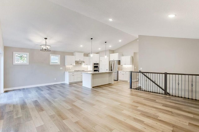 12620 Overlook Rd, Dayton, MN 55327 - kitchen with stainless steel appliances, open floor plan, light wood-type flooring, a chandelier, and vaulted ceiling